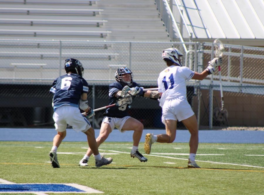 Senior Henry Kemp won the face-off and races toward teammates as SLUH defenders try to knock the ball free. The Hawklets controlled most aspects of the April 30, 2023 matchup--especially after the 1st quarter--en route to a 15-2 win.