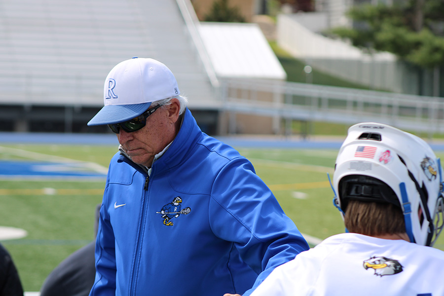Rockhurst athletic trainer Paul McGannon gets set to re-tape the ankle of senior Henry Kemp during a lacrosse match versus SLUH on April 30, 2023. McGannon, a Rockhurst grad, joined the staff in 2010.
