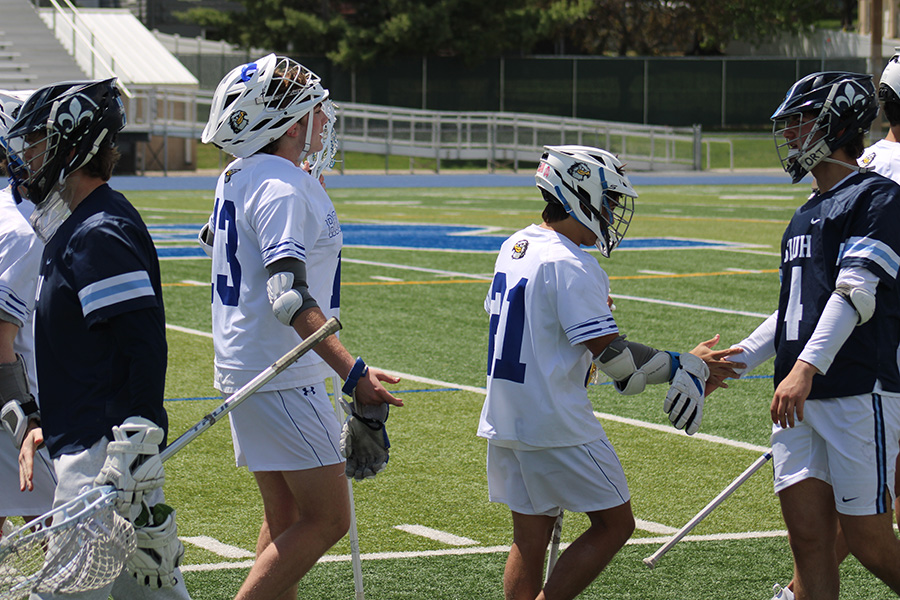 Junior Graham Fuemmeler and senior Brock Narciso go through the postgame handshake line following the Hawklets' 15-2 win over SLUH on April 30, 2023.