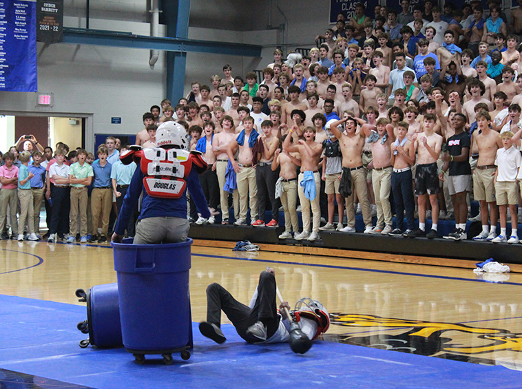 Sophomore Luke Franke looks down on his conquered foe, junior Joey Bonino, during trash can jousting on Sept. 8, 2023. Franke and the sophomores would go on to win the event by beating the freshmen in the finals during the pep assembly.
