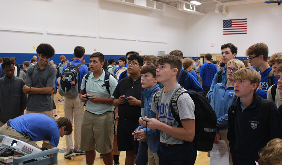 Samani Puhulu (teal polo), Alejandro Perez-Hernandez (black polo), Kyle Maher (blue quarter-zip) and Robbie Wright (gray T-shirt) take their turn playing a video game at the Video Game Club booth during the Freshman Club Fair on Sept. 21, 2023.