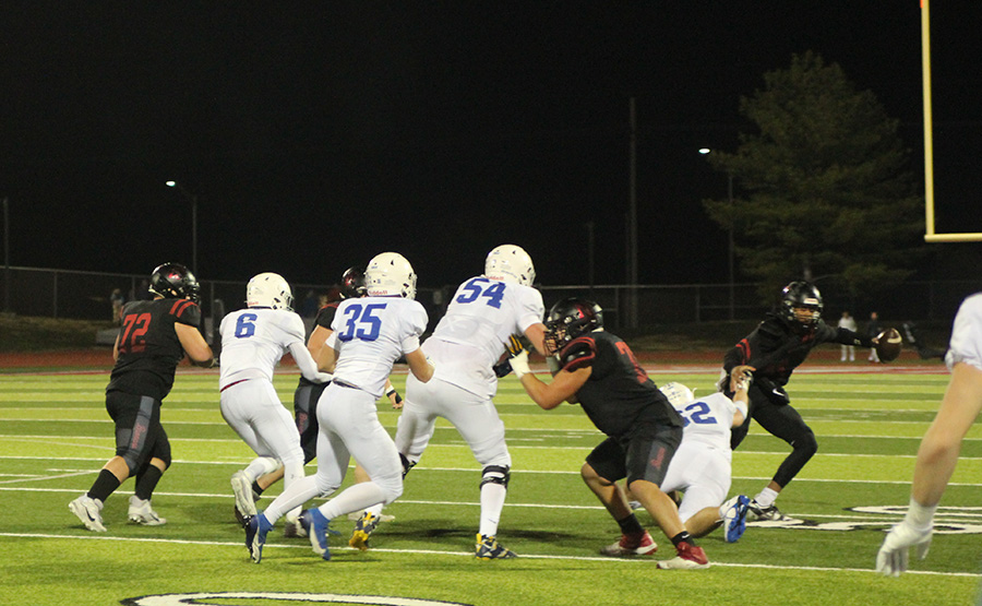 Sophomore defensive lineman Jack Manning (62) tries to get ahold of Lees Summit North quarterback Elijah Leonard late in the district championship game on Nov. 10, 2023. The Hawklets won 24-21, giving Rockhurst its first district crown in football since 2018.