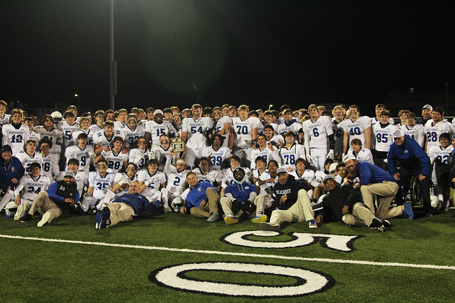 Senior quarterback Ethan Hanse (2) holds up the district championship trophy as the rest of the team poses for a picture after beating Lee's Summit North on Nov. 10, 2023. It's the Hawklets' first district crown in football since 2018.