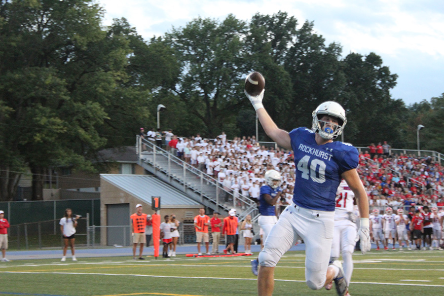 Senior Thomas Coppinger raises the football in triumph after scoring a touchdown against Bishop Miege on Sept. 22, 2023. Rockhurst jumped out to an early lead and held on 21-14 to claim the rivalry game.