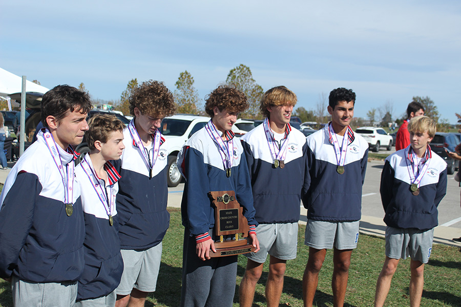 The cross country team prepares to pose with the state championship trophy on Nov. 8, 2024. The team won by 25 points, with the average for their top 7 finishers more than 13 seconds better than the 2nd place school.
Left to right: Bill Hayes, Jack Morrison, Justin Waldron, Henry Acorn, Andrew Davis, Kai Somasegaran and Jack McGovern