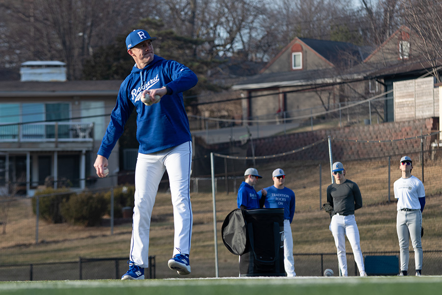 Head coach Will Gorden winds up to pitch during tryouts on March 3, 2025. This is Gorden's first season as the man in charge of Rockhurst's baseball program, but it's not his first time coaching for the Hawklets. He was an assistant from 2008-2011.