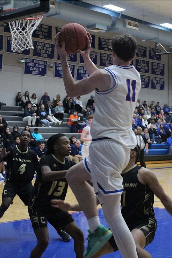 Senior Callen Eskew looks to find an open man as he drives behind the backboard against William Chrisman on March 5, 2025. The Hawklets won this opening game of districts 76-34.