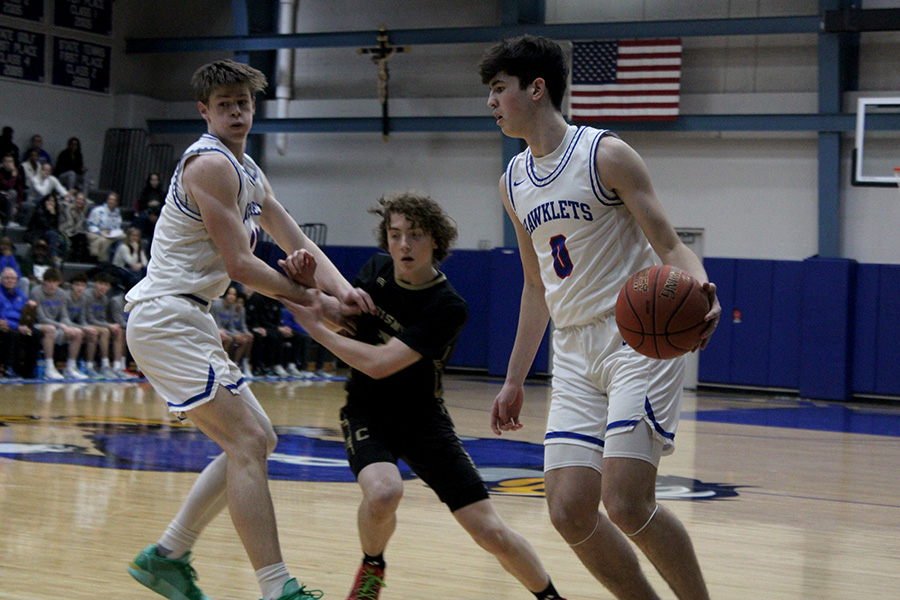 Junior Cohen Robinson sizes up what to do next after senior Callen Eskew set a screen for him during their March 5, 2025 opening game of districts against William Chrisman. The Hawklets were too much for the 3-24 Bears, winning 76-34.