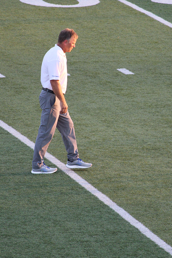 Head coach Kelly Donohoe walks the field as his team warms up for their game against Blue Springs on Oct. 3, 2025.