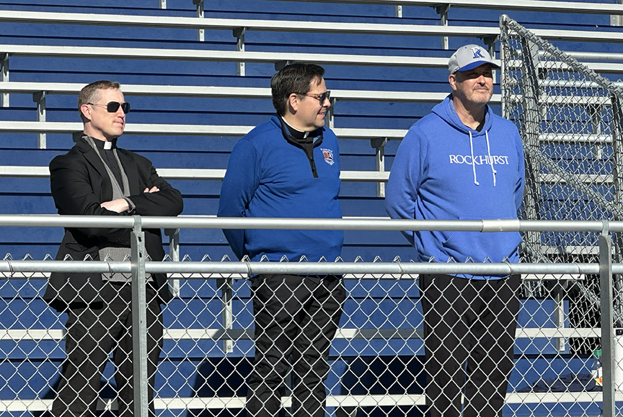 Stephen Kramer, S.J., Carlos Esparza, S.J. and David Laughlin listen as sophomore Kadence Hailey and his family address the people who came out for the Walk-a-Thon on Nov. 16, 2025 to raise money to cover costs associated with the kidney transplant the 16-year-old needs.